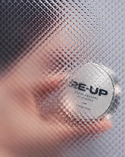 A Re-Up can held in hand, seen through reeded glass